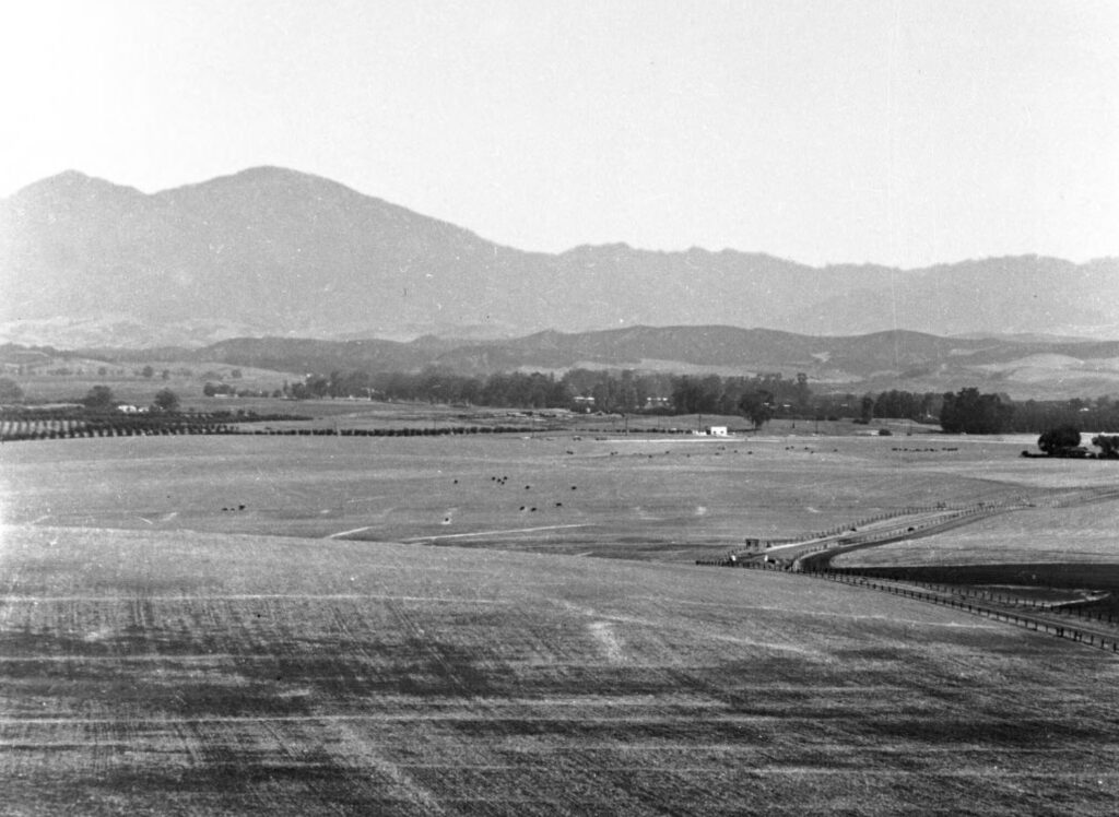 historic photo of rolling hills, farmland and mountain in distance